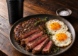 Steak and eggs plated on a wood table, a classic high-protein meal.
